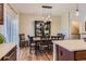 Elegant dining area with stylish light fixture and view to the kitchen; hardwood floors with a dark china cabinet at 535 Elmhurst Way # A, Highlands Ranch, CO 80129