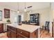 Elegant dining area with stylish light fixture and view to the kitchen; hardwood floors with a dark china cabinet at 535 Elmhurst Way # A, Highlands Ranch, CO 80129