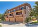 Exterior view of a multi-story home with multiple garage doors and balconies, showcasing its architecture at 535 Elmhurst Way # A, Highlands Ranch, CO 80129