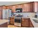 Well-equipped kitchen with stainless steel appliances, modern cabinetry, and stylish backsplash with hardwood floors at 535 Elmhurst Way # A, Highlands Ranch, CO 80129