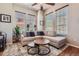 Inviting living room showcasing a comfortable sectional sofa, ceiling fan, and abundant natural light from the large windows at 535 Elmhurst Way # A, Highlands Ranch, CO 80129