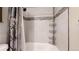 A modern bathroom showcasing a shower-tub combo with sleek fixtures and a tiled surround. The shower has a unique shelving at 32350 E 137Th Way, Brighton, CO 80603