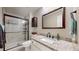 This bathroom offers granite counters, and a tiled shower with glass door for a sleek design at 32350 E 137Th Way, Brighton, CO 80603