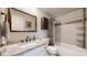 A clean bathroom features a granite vanity, white cabinets, and a shower-tub combo with decorative tile at 32350 E 137Th Way, Brighton, CO 80603