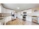 A kitchen with stainless steel appliances, white cabinets, and wood-look flooring offers a clean and modern space at 32350 E 137Th Way, Brighton, CO 80603