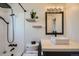 Bright bathroom with modern fixtures including a new vanity, rainfall shower, and hexagon tile at 4600 Dillon St, Denver, CO 80239