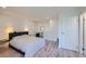 Cozy bedroom boasts wood flooring, a contemporary bed frame and modern lighting at 4600 Dillon St, Denver, CO 80239