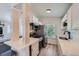 Efficient kitchen featuring white cabinets, stainless steel appliances, and seamless connection to living area at 4600 Dillon St, Denver, CO 80239