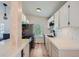 Galley-style kitchen with white cabinetry, modern appliances, and stylish backsplash with a view into the living area at 4600 Dillon St, Denver, CO 80239