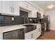 Modern kitchen featuring stainless steel appliances, black subway tile backsplash, and white countertops at 2 Adams St # 1504, Denver, CO 80206