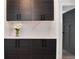 Storage area with modern dark wood cabinets, white countertop and backsplash, and stylish vase of flowers at 2 Adams St # 1504, Denver, CO 80206