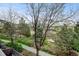 Inviting balcony view showcasing lush landscaping and mature trees on a sunny day at 2958 Syracuse St # 204, Denver, CO 80238