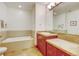 Bathroom featuring a soaking tub, tile flooring, cherry vanity with plenty of counter space and recessed lighting at 2958 Syracuse St # 204, Denver, CO 80238