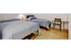Cozy bedroom featuring two twin beds with blue comforters and light hardwood flooring at 2958 Syracuse St # 204, Denver, CO 80238