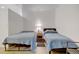 Simple bedroom featuring two twin beds, hardwood floors, and a nightstand with lamp at 2958 Syracuse St # 204, Denver, CO 80238