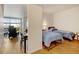 Bedroom view showing twin beds and a glimpse into the living room with natural light at 2958 Syracuse St # 204, Denver, CO 80238