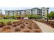 Apartment building with lush landscaping, and a curved sidewalk showcasing a modern and inviting living space at 2958 Syracuse St # 204, Denver, CO 80238