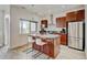 Kitchen island featuring a granite countertop, stainless steel appliances, ample cabinet space, and barstool seating at 2958 Syracuse St # 204, Denver, CO 80238