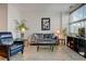 Comfortable living room with a gray sofa, lamps, plants, and a large window at 2958 Syracuse St # 204, Denver, CO 80238