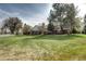 Large backyard with lush green grass and mature trees with a white fence at 10 Martin Ln, Cherry Hills Village, CO 80113