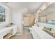 Well-lit bathroom featuring white cabinets, patterned wallpaper, and a bathtub with a shower at 10 Martin Ln, Cherry Hills Village, CO 80113