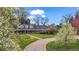 Elegant home with a brick facade, columned front porch, circular driveway, and flowering trees at 10 Martin Ln, Cherry Hills Village, CO 80113