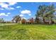 Spacious front yard with lush green grass, mature trees, and a classic brick home at 10 Martin Ln, Cherry Hills Village, CO 80113