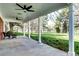 Covered patio with ceiling fans, elegant columns, and a serene view of the landscaped yard at 10 Martin Ln, Cherry Hills Village, CO 80113