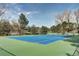 Well-maintained outdoor tennis court featuring a green and blue surface with mature trees nearby at 10 Martin Ln, Cherry Hills Village, CO 80113