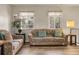 A living room showcasing natural light, two sofas, laminate flooring, and neutral decor at 12829 E Oregon Dr, Aurora, CO 80012