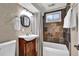 Updated bathroom features wood vanity, vessel sink, framed mirror, and tiled bath surround at 4262 E Fremont Pl, Centennial, CO 80122