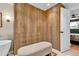 Bright walk-in closet featuring custom wood cabinetry, drawers, bench, and door to bedroom at 4262 E Fremont Pl, Centennial, CO 80122