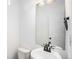 A tidy powder room features a white vanity with modern faucet and a large framed mirror, creating a bright, clean aesthetic at 19096 E 55Th Ave, Denver, CO 80249