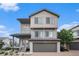 Two-story home featuring neutral siding, brick driveway, attached garage, and a cozy front porch at 19096 E 55Th Ave, Denver, CO 80249