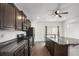Kitchen featuring dark wood cabinets, stainless steel appliances, and an oversized island with a sink at 19096 E 55Th Ave, Denver, CO 80249