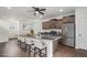Open kitchen with a large island, stainless steel appliances, and dark wood cabinetry at 19096 E 55Th Ave, Denver, CO 80249