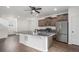 Modern kitchen features stainless steel appliances, dark cabinets, and large island with sink, great for cooking and entertaining at 19096 E 55Th Ave, Denver, CO 80249