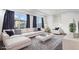 Bright living room with modern furnishings, plush white sofas, and large windows with elegant curtains at 19096 E 55Th Ave, Denver, CO 80249