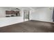 View of the open living room with carpet and view to the kitchen and outside at 19096 E 55Th Ave, Denver, CO 80249
