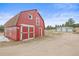 Well-maintained red barn on the property, featuring large doors and a rustic design at 512 County Road 136, Elizabeth, CO 80107