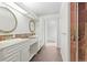 Bright bathroom with dual sinks, white cabinets, and tile accents at 512 County Road 136, Elizabeth, CO 80107