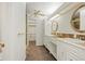 Well-lit bathroom with double sinks, white cabinets, and a convenient walk-in closet at 512 County Road 136, Elizabeth, CO 80107