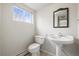 Cozy bathroom with pedestal sink and a window at 512 County Road 136, Elizabeth, CO 80107