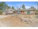Exterior of house featuring brick, siding, green door, and lush natural surroundings at 512 County Road 136, Elizabeth, CO 80107