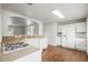Bright kitchen featuring white appliances and cabinets with hardwood floors at 512 County Road 136, Elizabeth, CO 80107