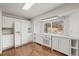 Bright kitchen with white cabinets, modern appliances, and a window overlooking the wooded yard at 512 County Road 136, Elizabeth, CO 80107