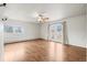 Living room with hardwood floors, a ceiling fan, white walls, and sliding glass doors at 512 County Road 136, Elizabeth, CO 80107