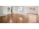 Empty living room with hardwood floors, neutral paint, and an open layout connecting to the dining area and stairs at 512 County Road 136, Elizabeth, CO 80107