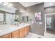 Well-lit bathroom featuring a double vanity, large mirror, and separate shower and tub at 529 Uinta Way, Denver, CO 80230