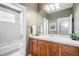 Bathroom with a tiled shower over the tub, modern vanity, and a decorative mirror at 529 Uinta Way, Denver, CO 80230
